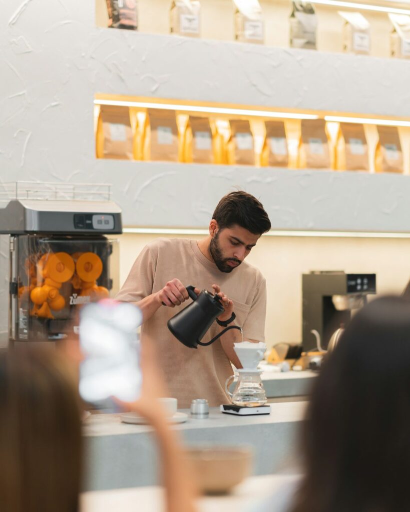 Etkinlik alanında ziyaretçilerin önünde kahve hazırlayan barista