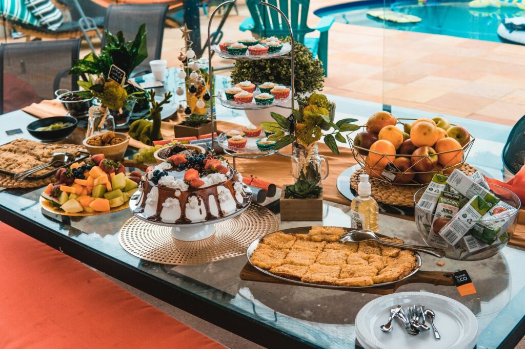Poolside party with a table of cake, fruit and desserts