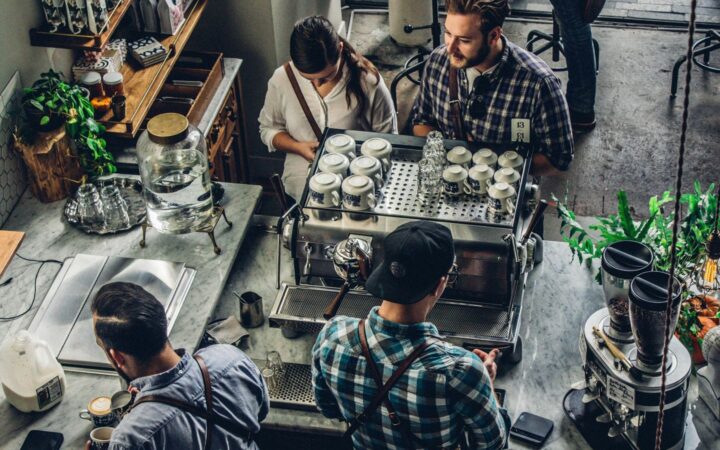 Kahve barında espresso makinesi başında çalışan baristalar, üstten görünüm