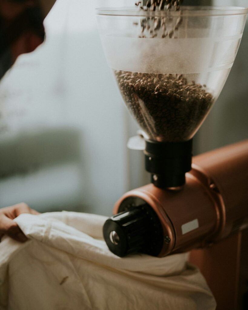 Freshly ground coffee beans coming out of a coffee grinder