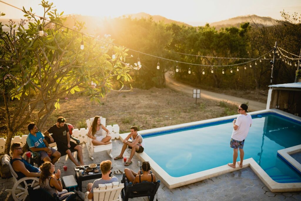 Guests gathered around a villa pool at sunset